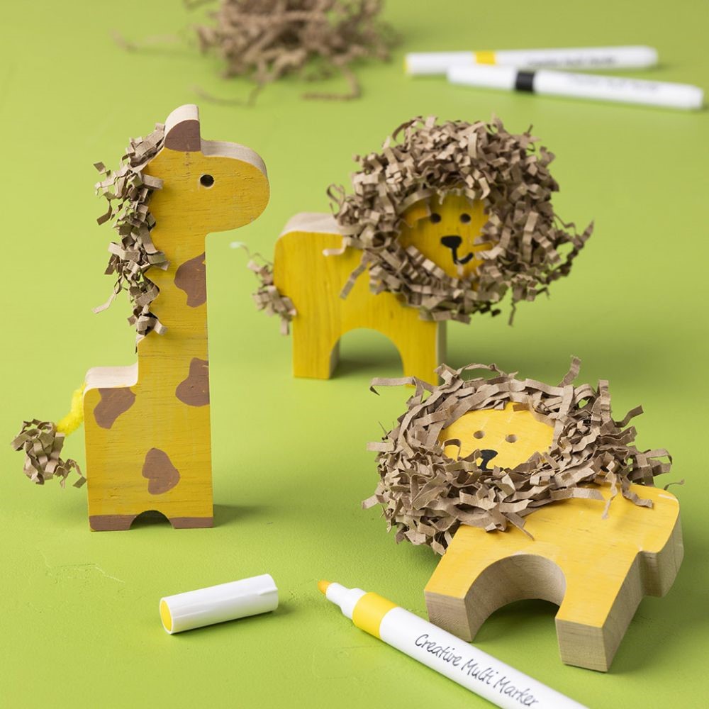 Wilde houten dieren versierd met stiften en versnipperd papier