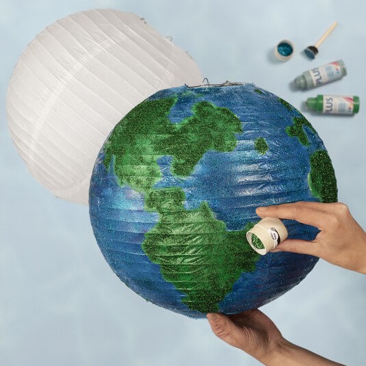 Een wereldbol van een rijstpapierlamp versierd met hobbyverf en bio glitter