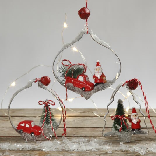 Hangende kerstdecoraties met miniatuurfiguren in uitstekers